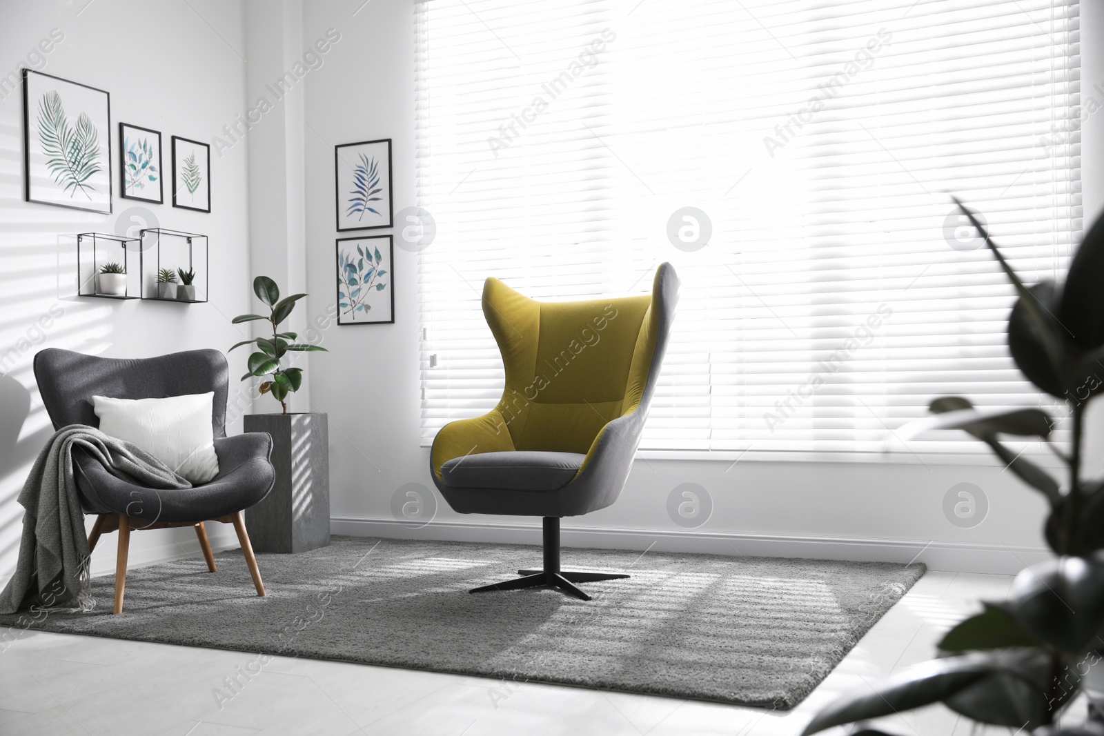 Photo of Comfortable armchairs near window in light room