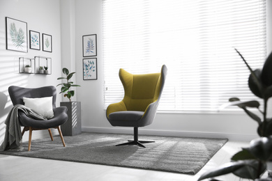 Comfortable armchairs near window in light room