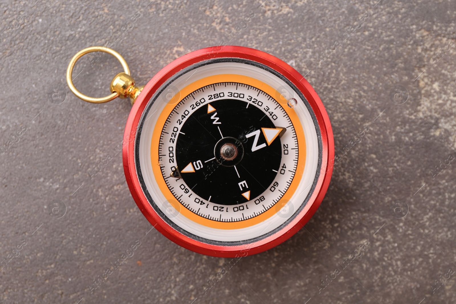 Photo of One compass on grey textured background, top view