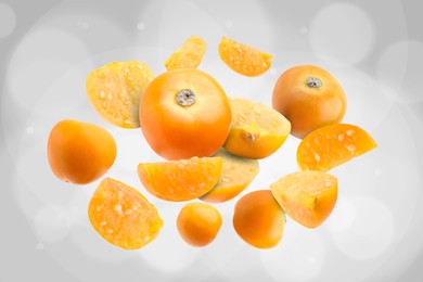 Image of Ripe orange physalis fruits falling on light grey background