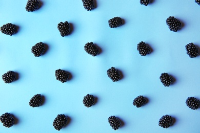 Flat lay composition with ripe blackberries on blue background