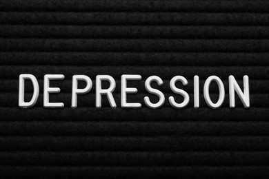 Word Depression made of white letters on black fabric, top view