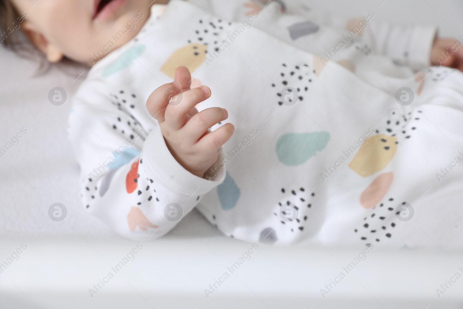 Photo of Cute little baby lying in crib, closeup