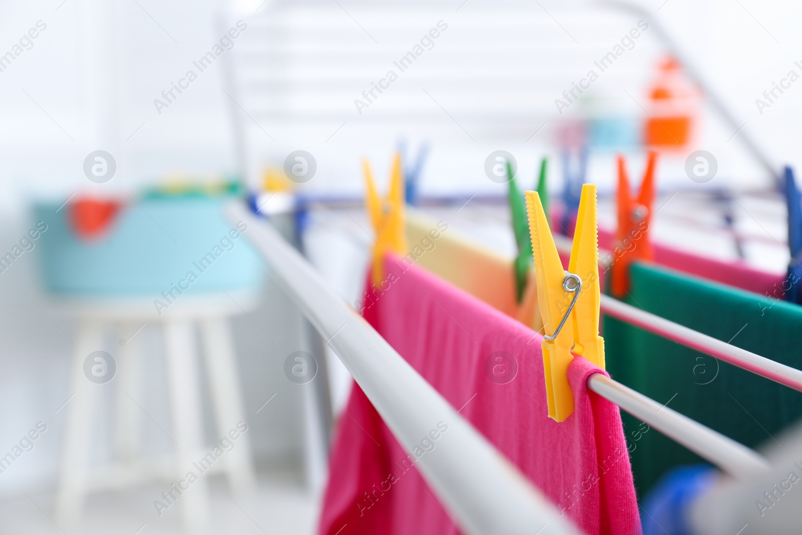 Photo of Clean laundry hanging on drying rack indoors, closeup