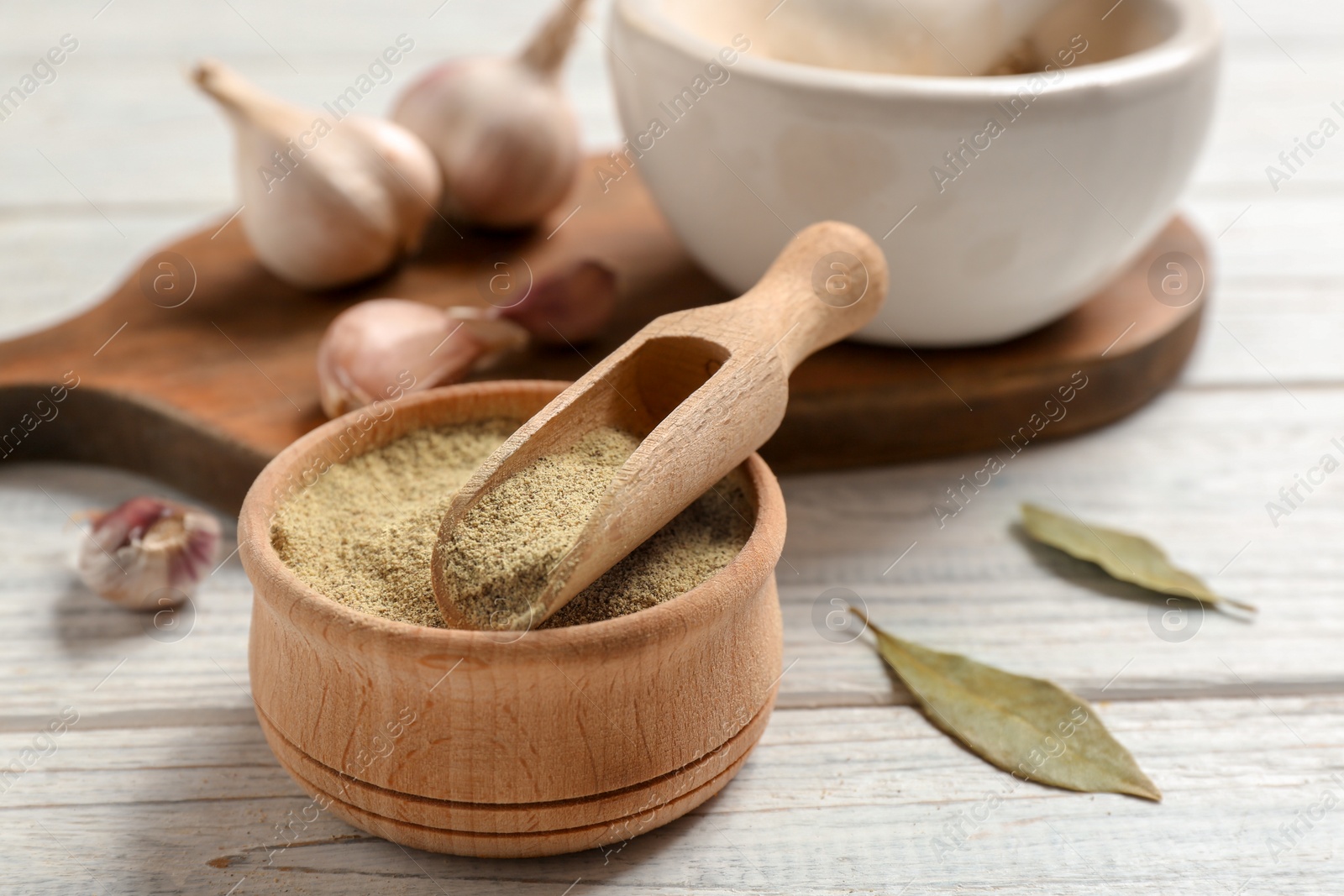 Photo of Composition with powdered pepper in scoop and bowl on wooden table