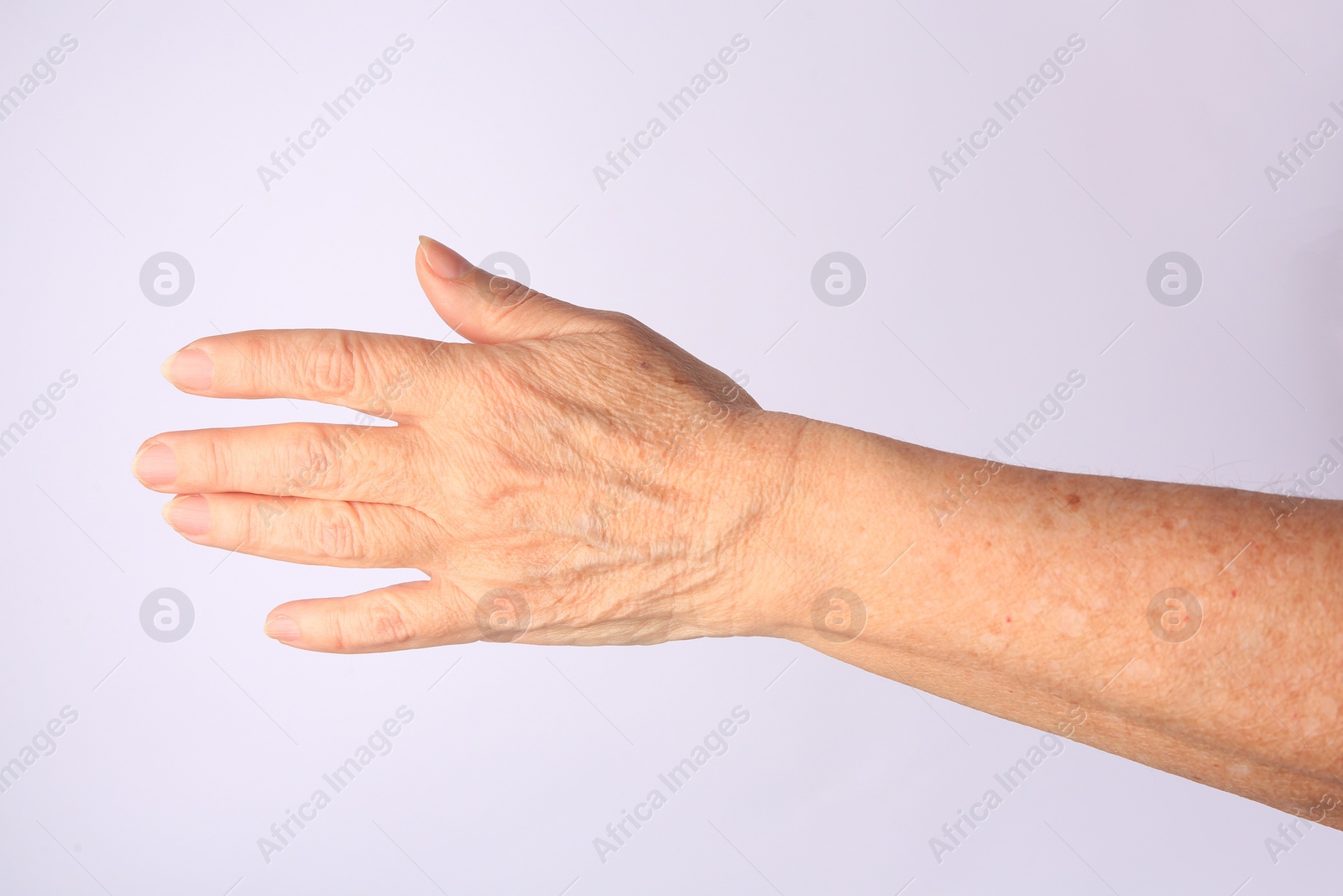 Photo of Closeup view of woman's hand with aging skin on white background