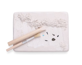 Photo of Educational toy for motor skills development. Excavation kit (plaster, wooden chisel, brush and gemstones) on white background, top view