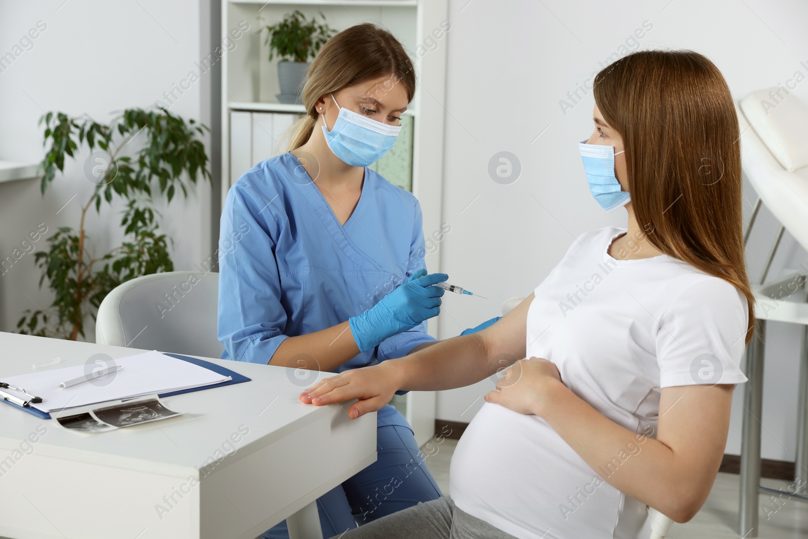 Photo of Doctor giving injection to pregnant woman in hospital