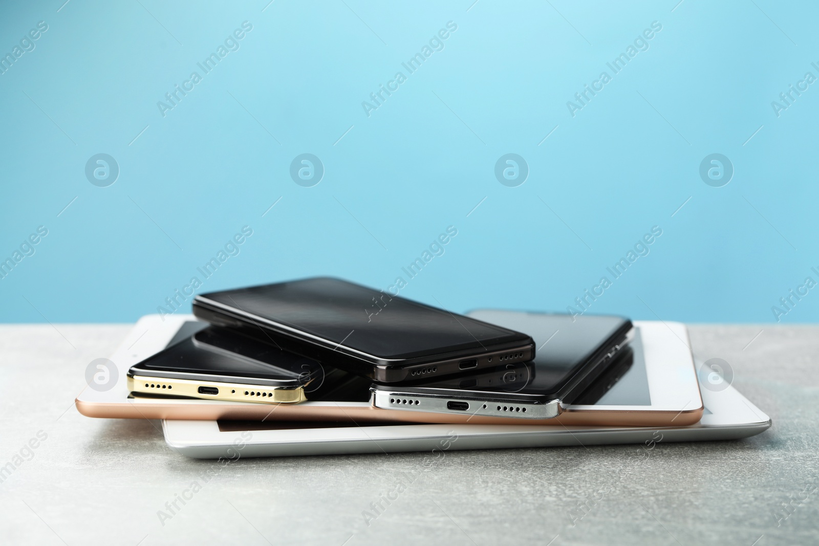 Photo of Stack of electronic devices on grey table, closeup