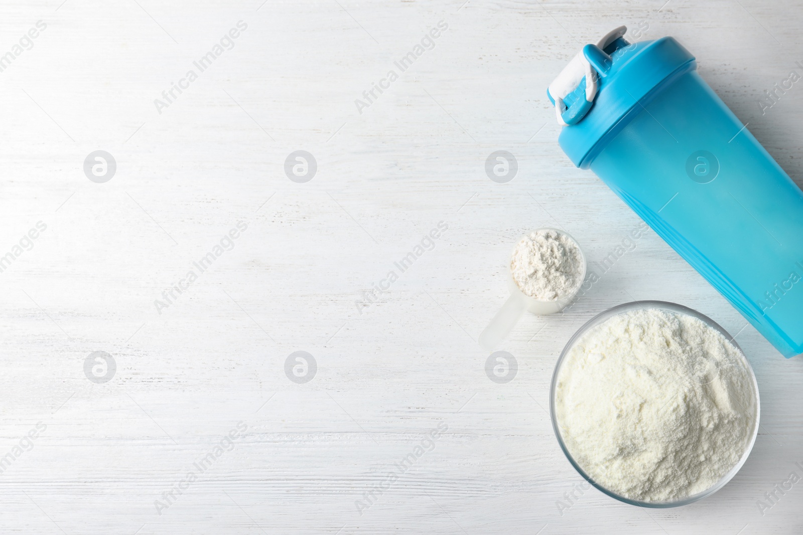 Photo of Flat lay composition with protein powder on white wooden table, space for text