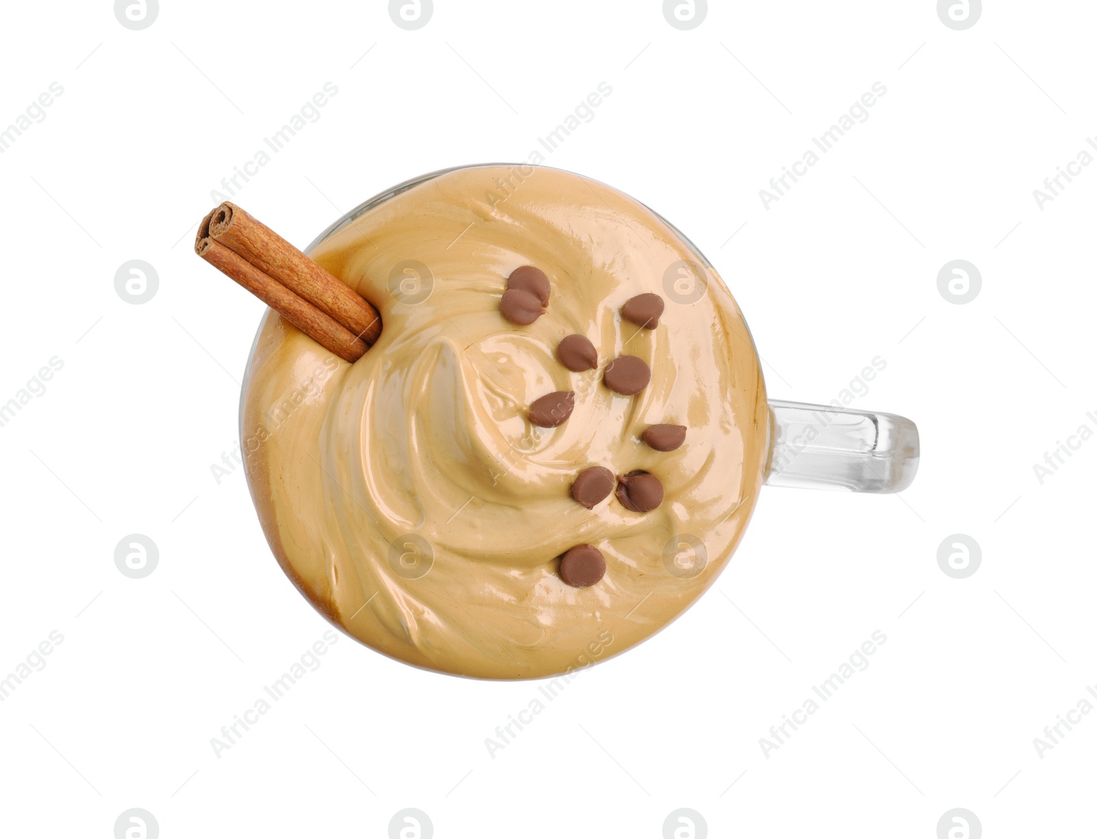 Photo of Glass mug of delicious dalgona coffee with cinnamon stick and chocolate chips isolated on white, top view
