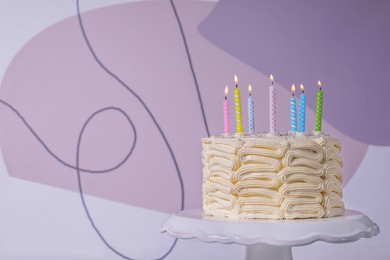 Photo of Delicious cake with cream burning candles on color background. Space for text