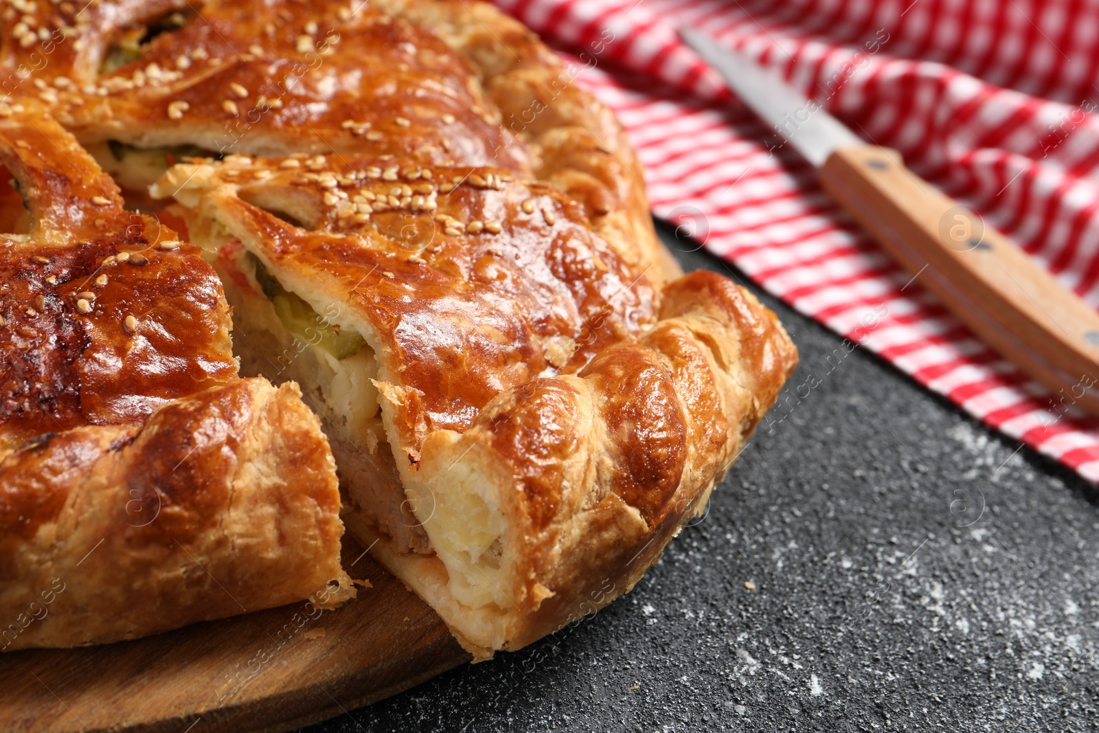 Photo of Cut delicious homemade pie on black table, closeup