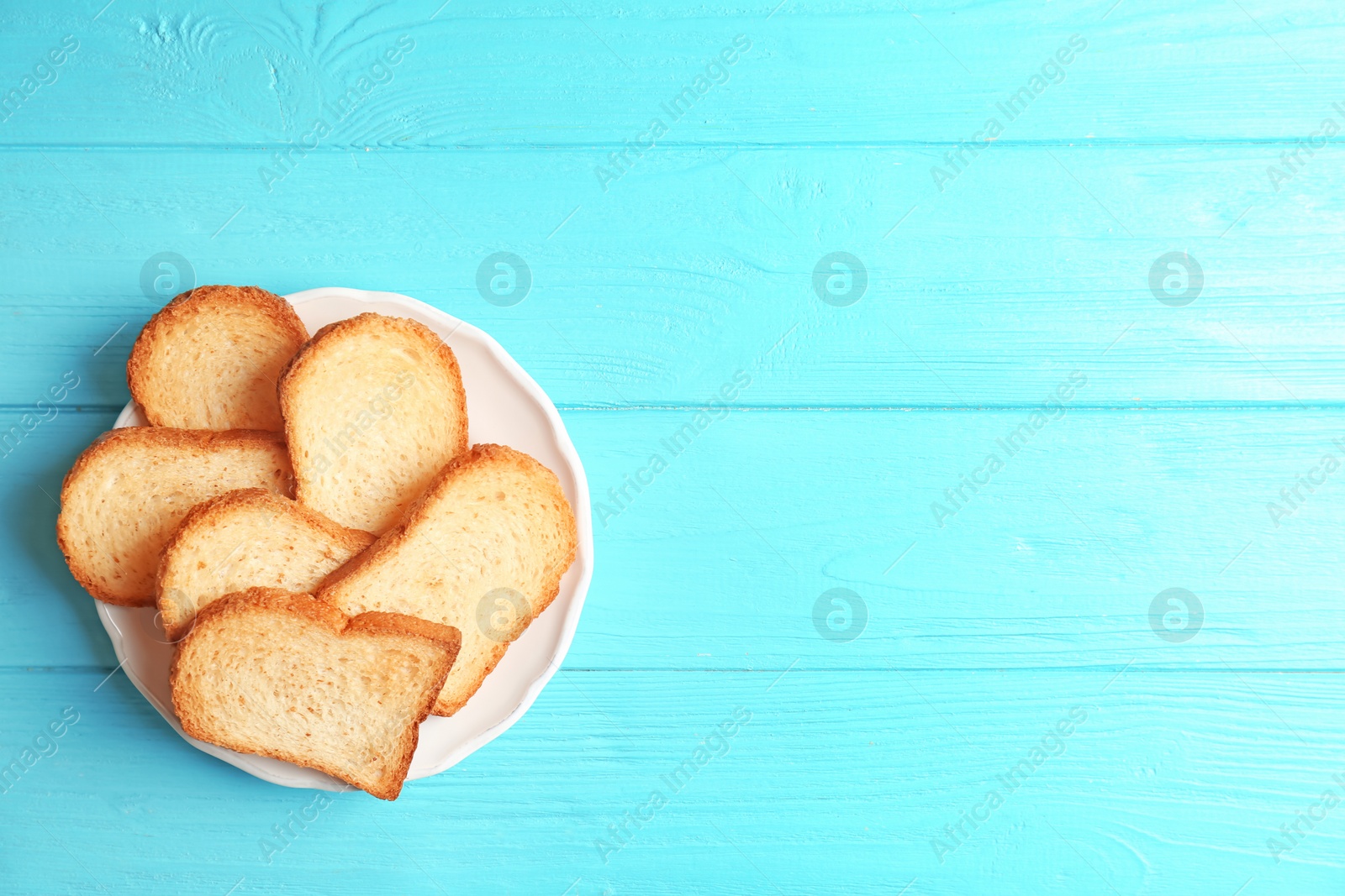 Photo of Plate with toasted bread on wooden background, top view