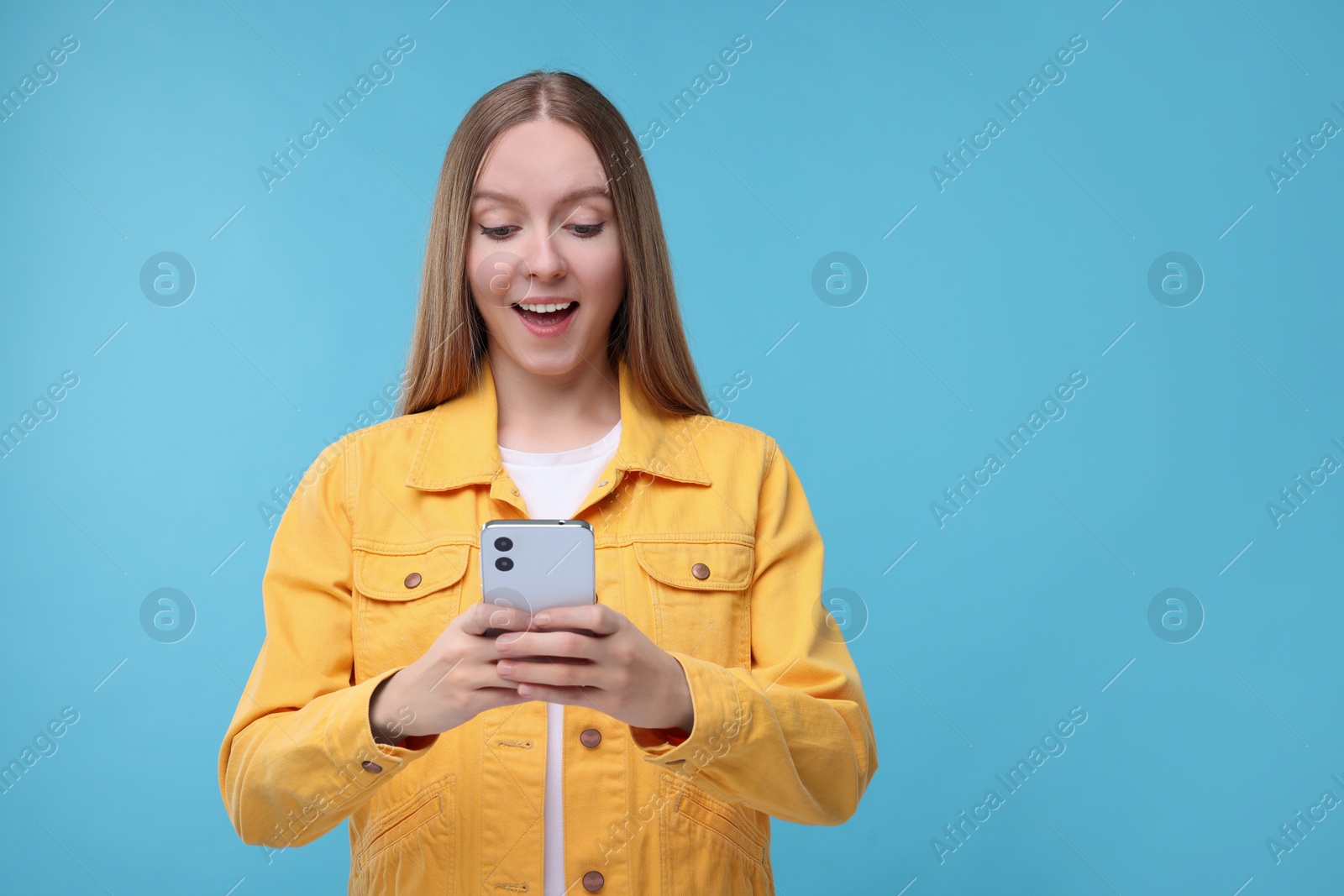 Photo of Woman sending message via smartphone on light blue background, space for text