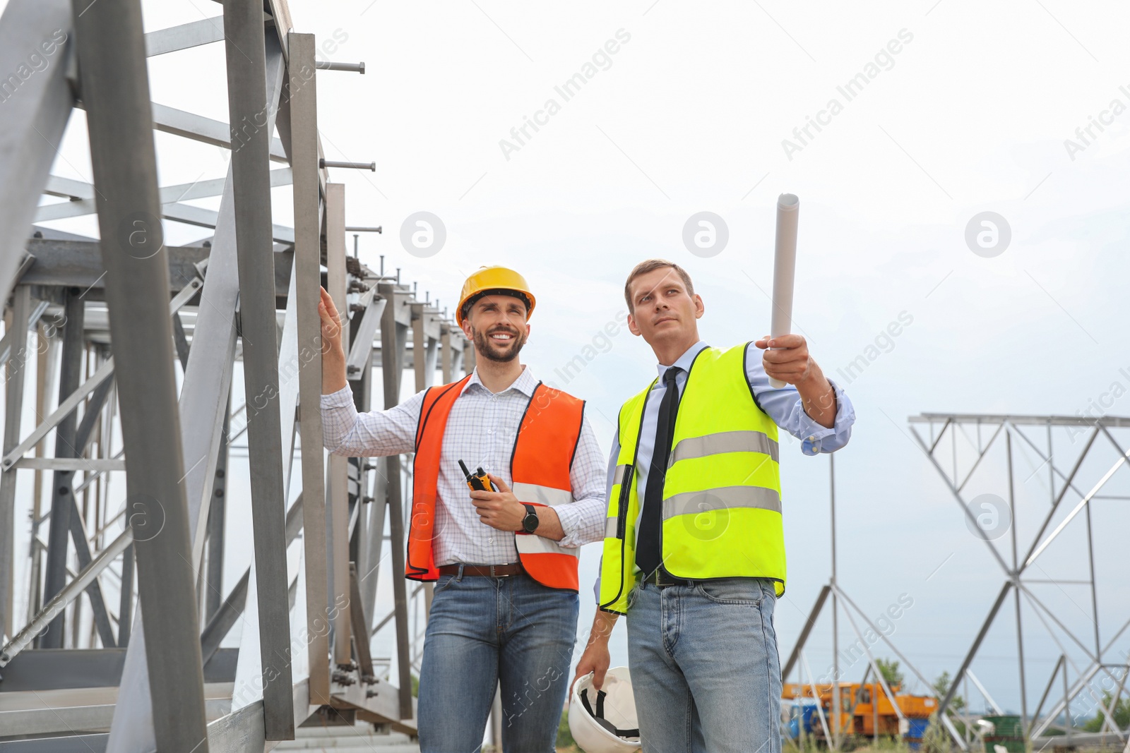 Photo of Professional engineers working on installation of electrical substation outdoors