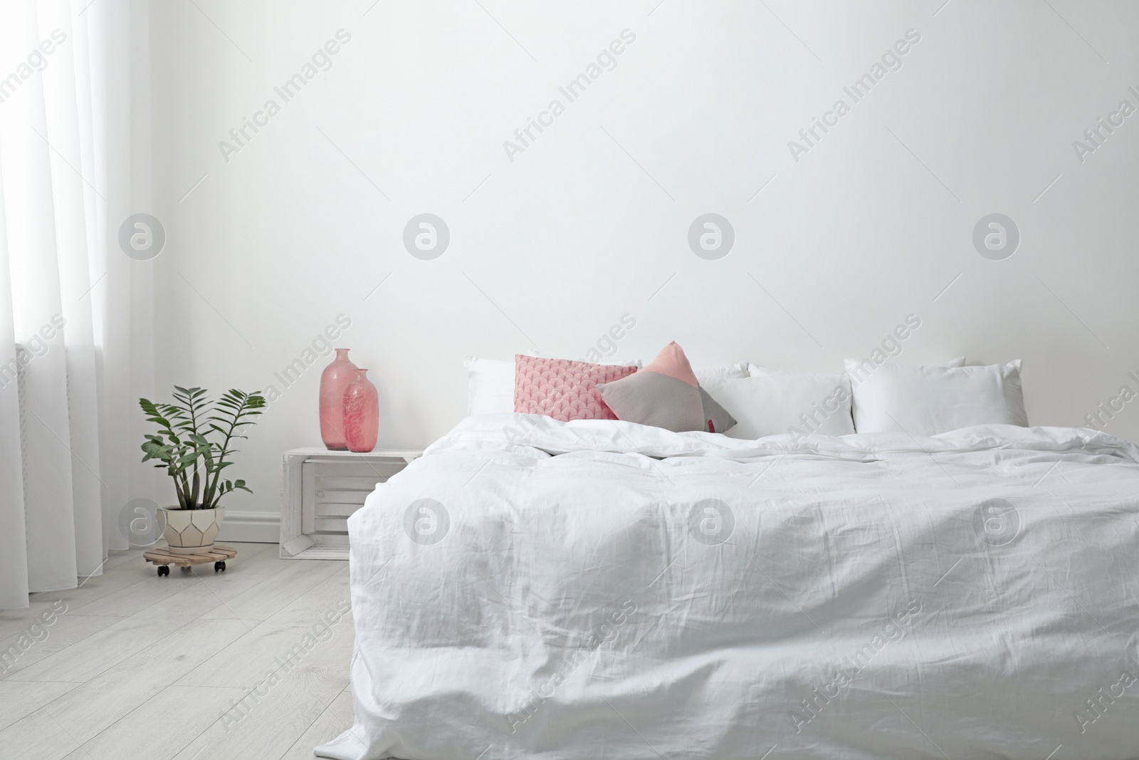Photo of Comfortable bed with soft pillows in room interior