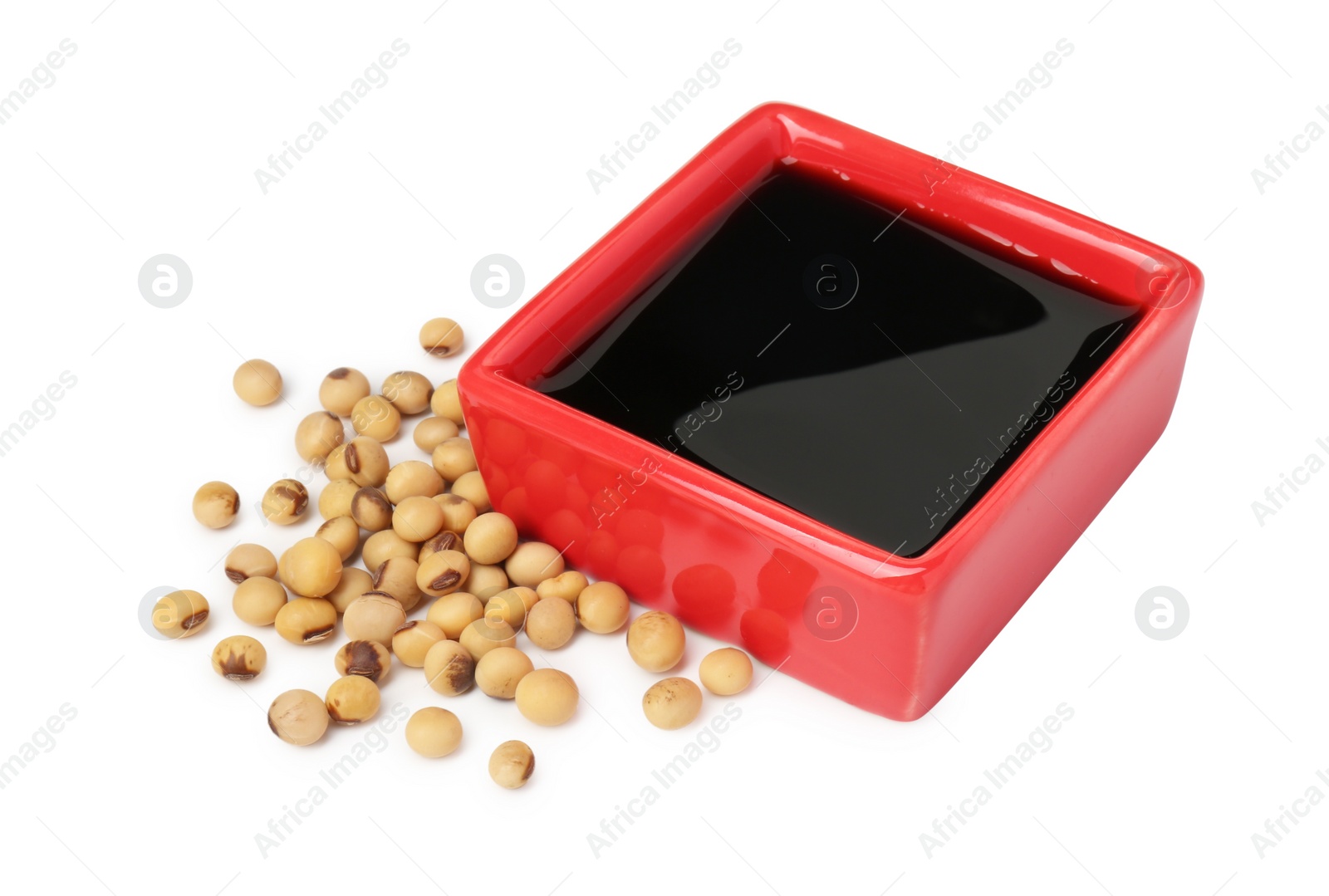 Photo of Tasty soy sauce in bowl and soybeans isolated on white