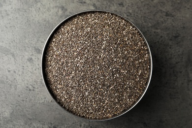 Bowl with chia seeds on grey table, top view