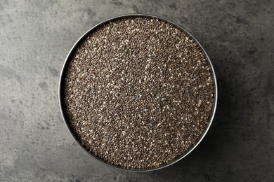 Photo of Bowl with chia seeds on grey table, top view