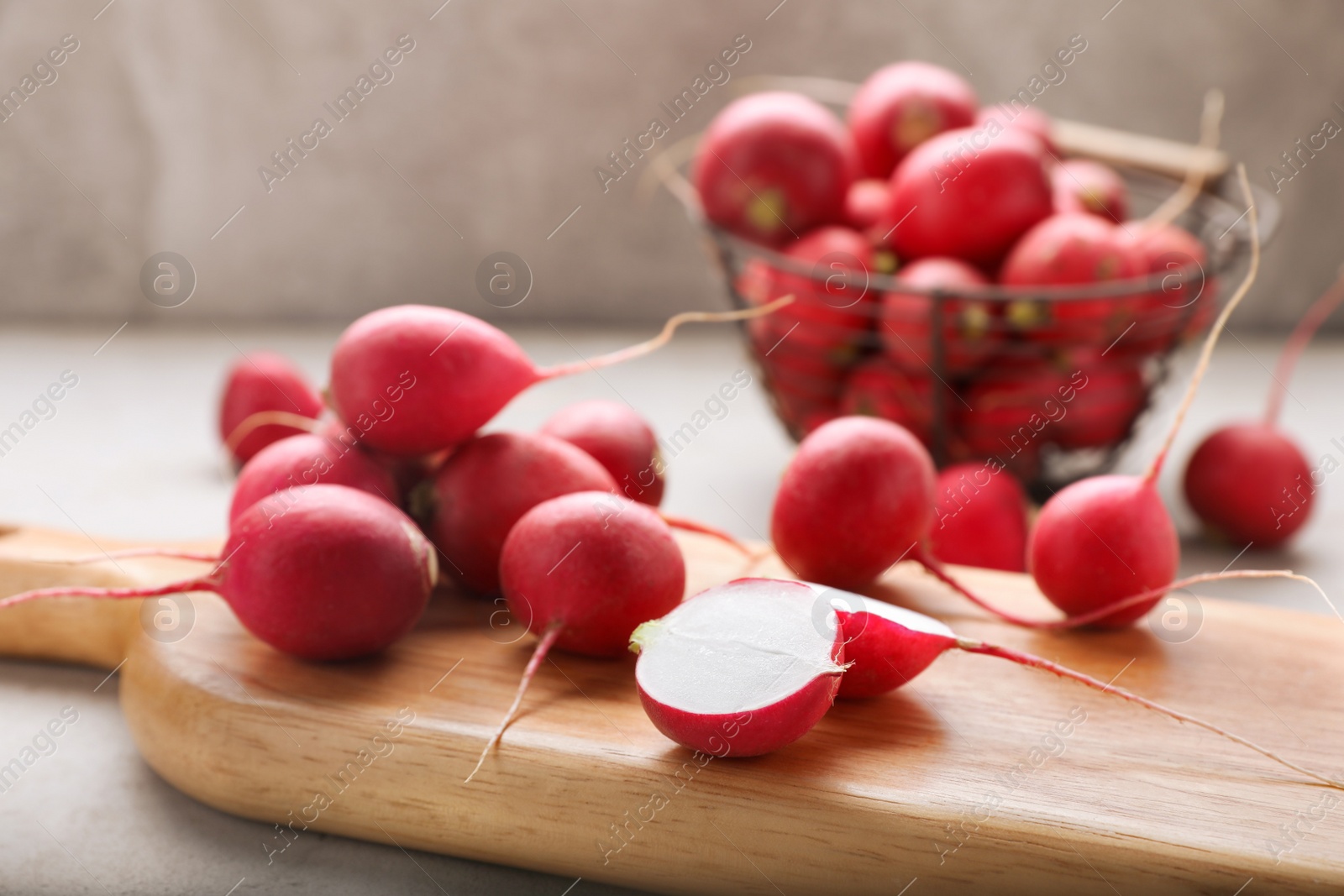 Photo of Wooden board with fresh ripe radishes on table, closeup