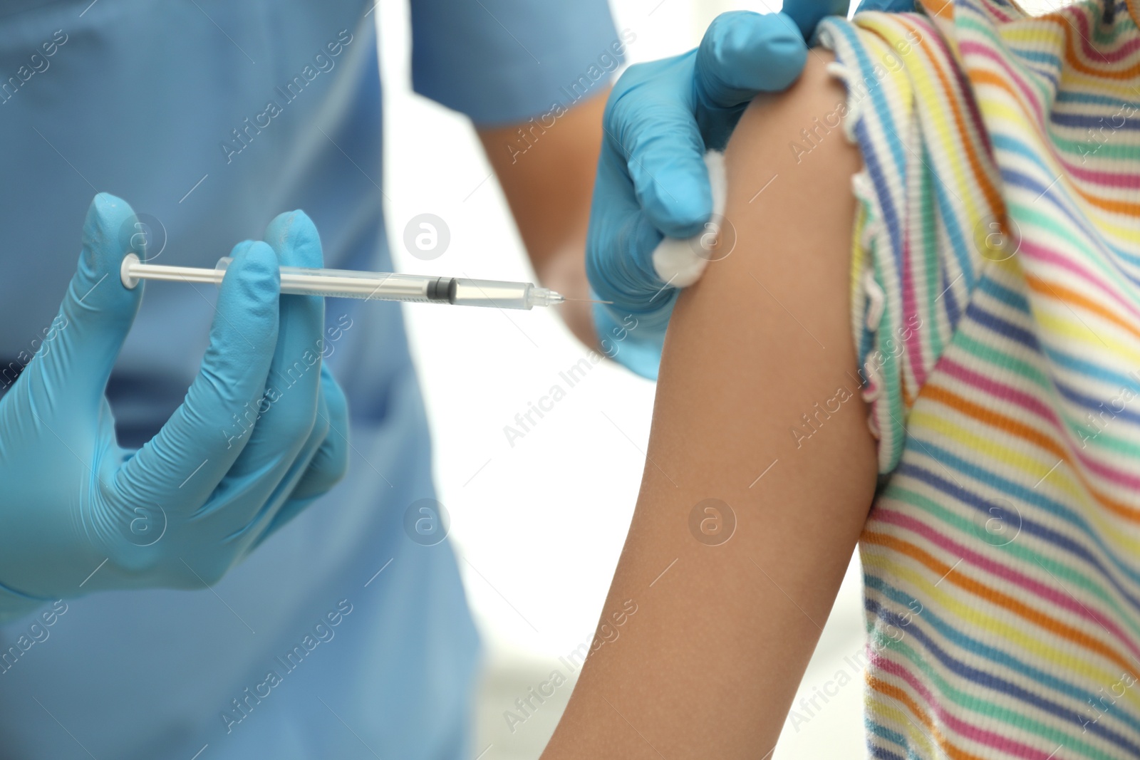 Photo of Doctor vaccinating little child in clinic, closeup