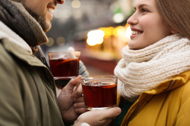 Happy couple with mulled wine at winter fair