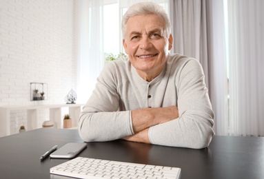 Mature man using video chat at home, view from web camera