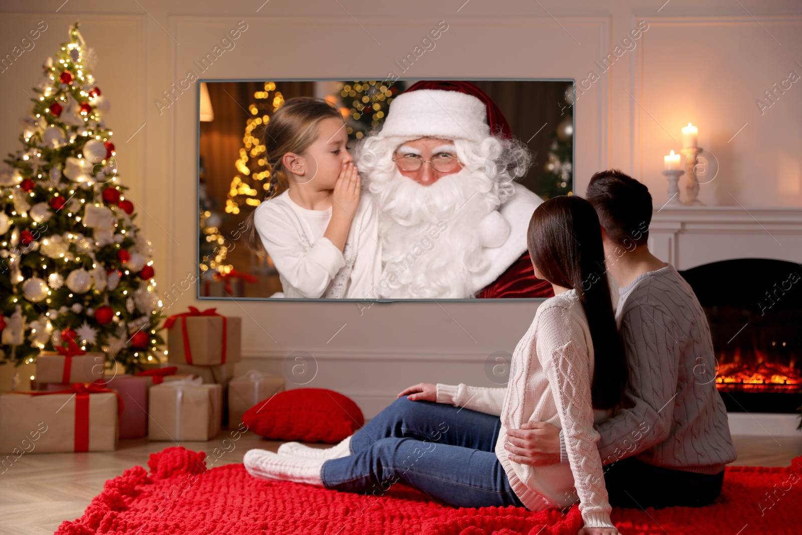 Image of Couple watching TV movie in room decorated for Christmas