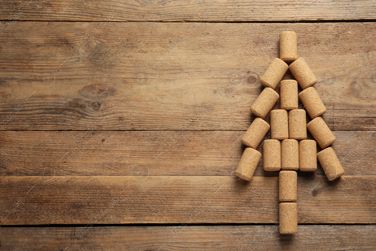 Photo of Christmas tree made of wine corks on wooden table, top view. Space for text