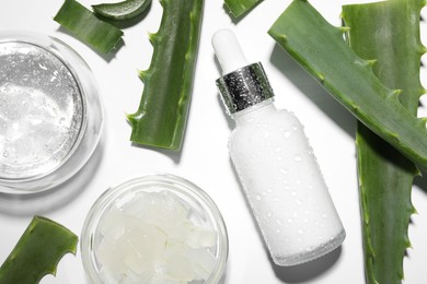 Photo of Flat lay composition with cosmetic products and cut aloe vera on white background