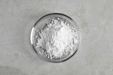 Photo of Petri dish with calcium carbonate powder on light grey table, top view