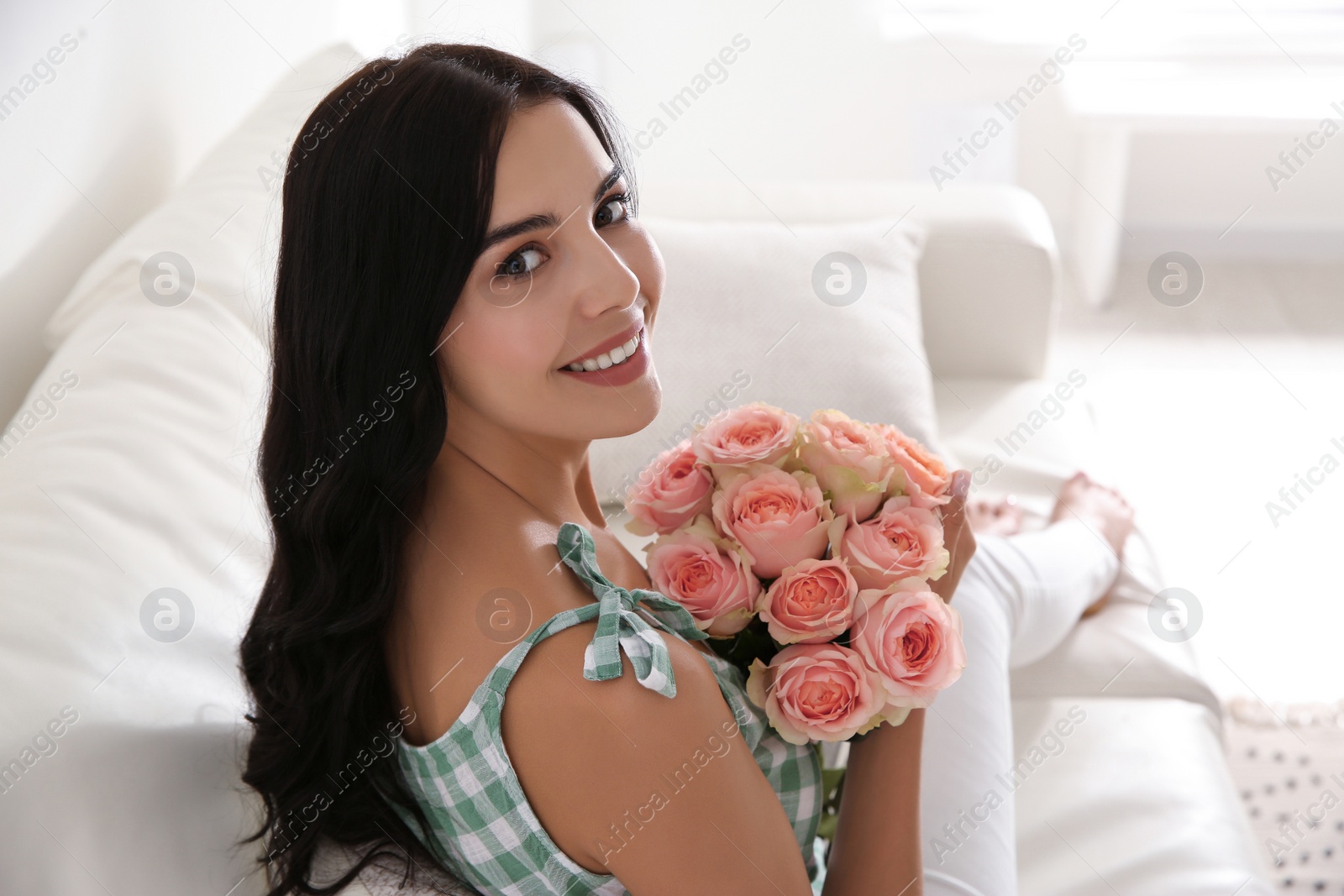 Photo of Young woman with beautiful bouquet at home