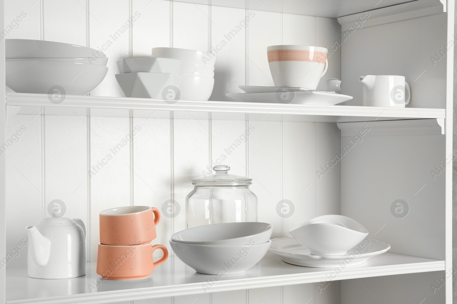 Photo of Stylish storage stand with different ceramic dishware at home