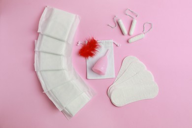 Photo of Menstrual pads and other feminine hygiene products on pink background, flat lay