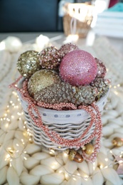 Photo of Beautiful Christmas tree baubles and fairy lights on white knitted fabric