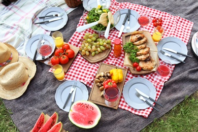 Photo of Blanket with food prepared for summer picnic outdoors