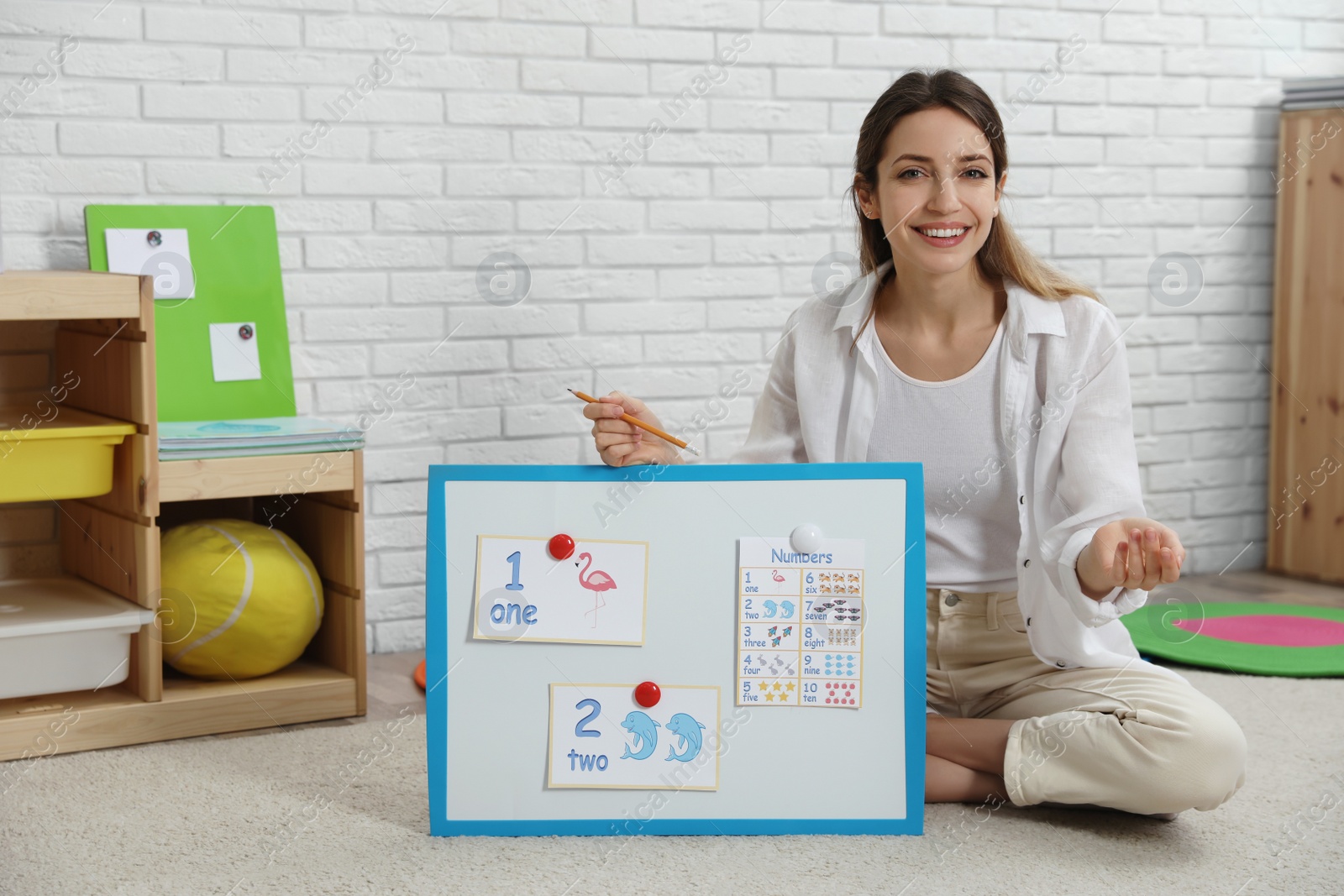 Photo of Happy female English teacher giving lesson in elementary school