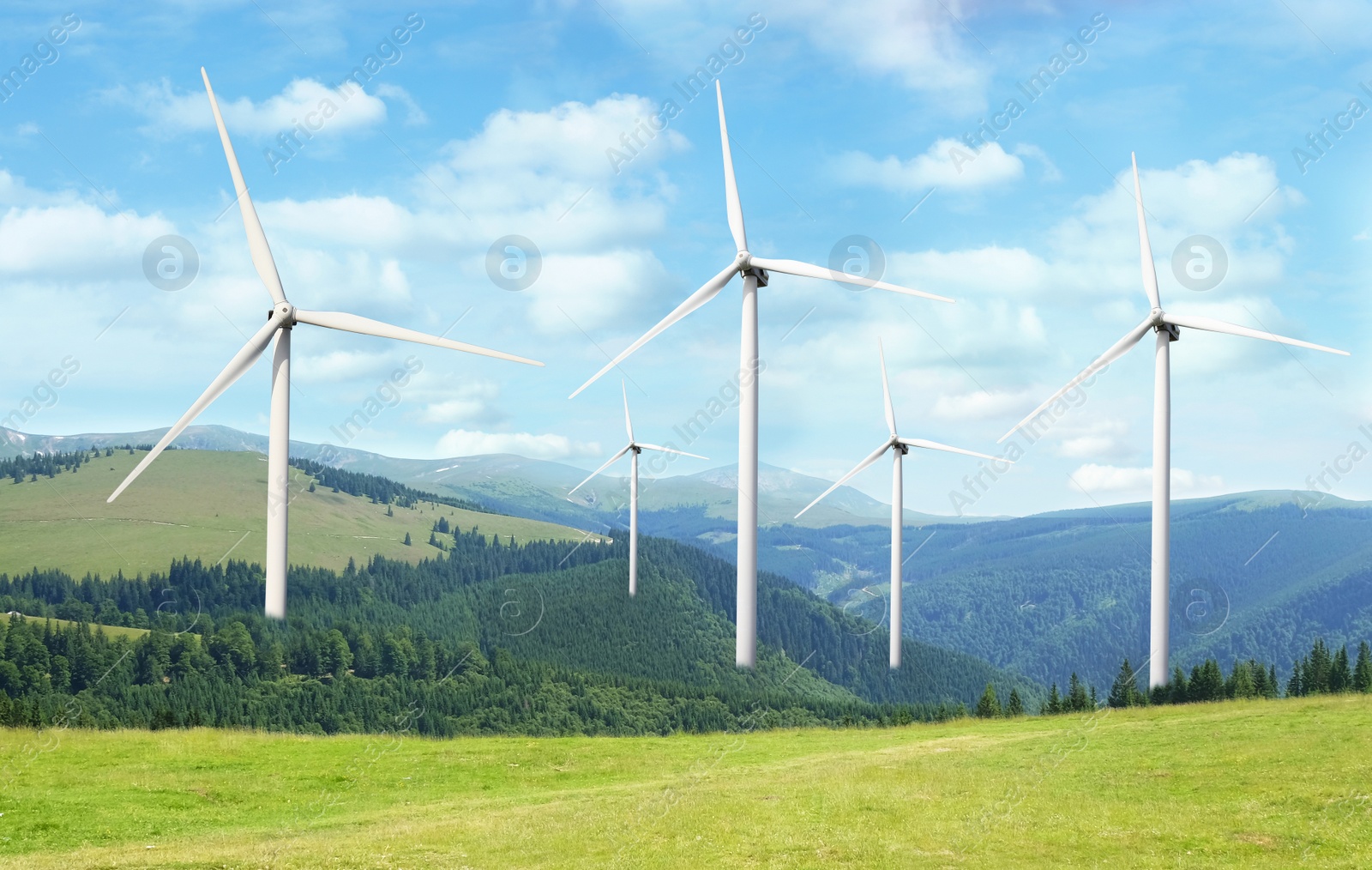 Image of Alternative energy source. Wind turbines in mountains under blue sky