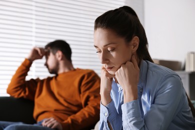 Offended couple ignoring each other after quarrel indoors, selective focus. Relationship problems