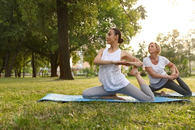 Women practicing yoga in park at morning, space for text