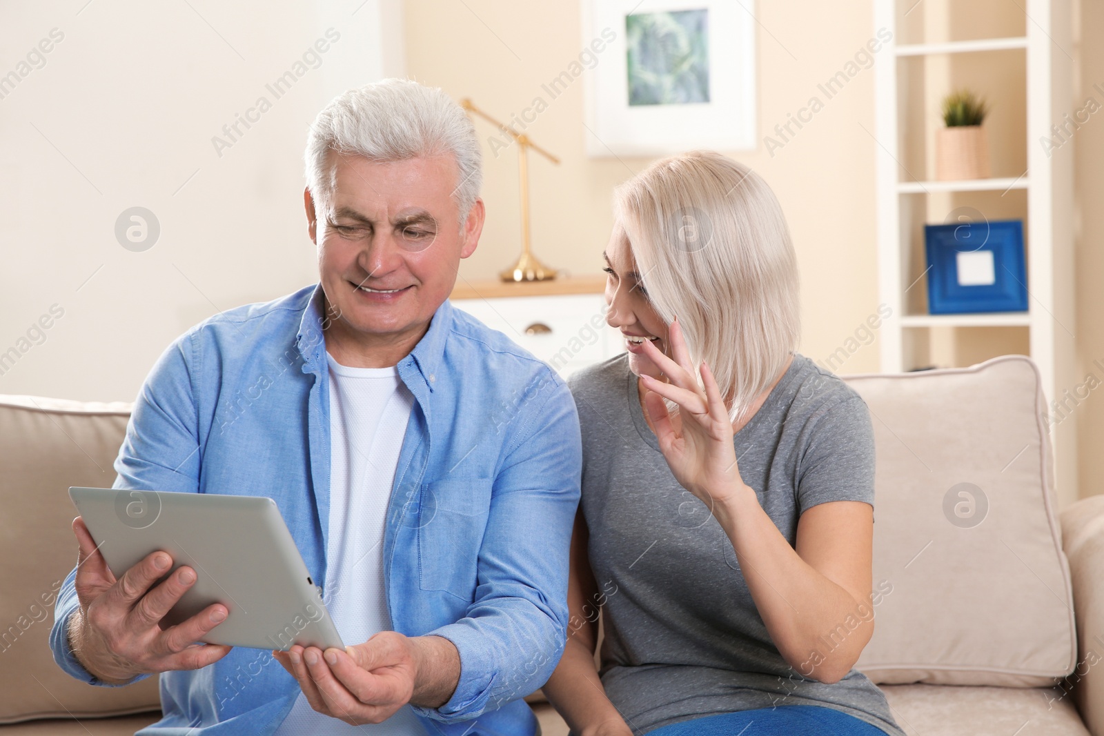 Photo of Mature couple using video chat on tablet at home