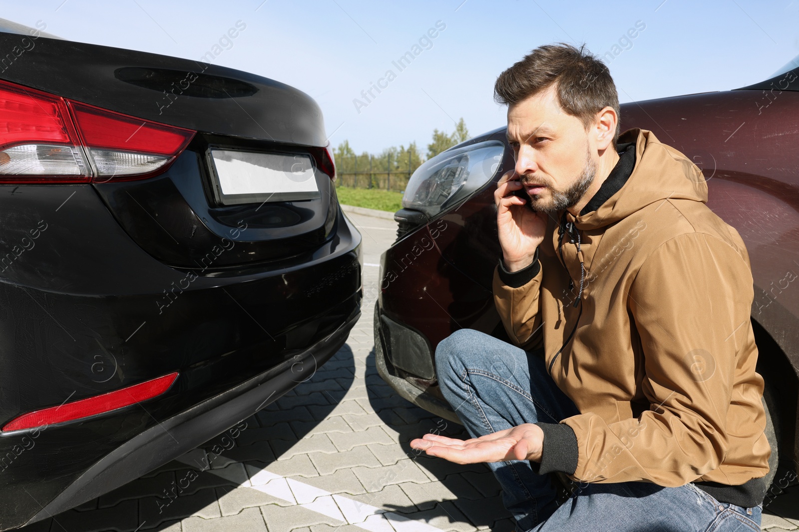 Photo of Man talking on phone near car with scratch outdoors Auto accident