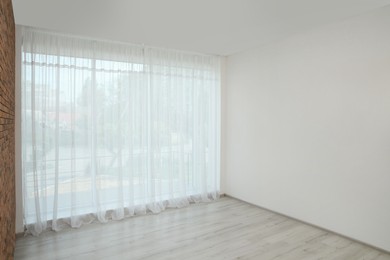 Photo of Empty room with white wall and large window