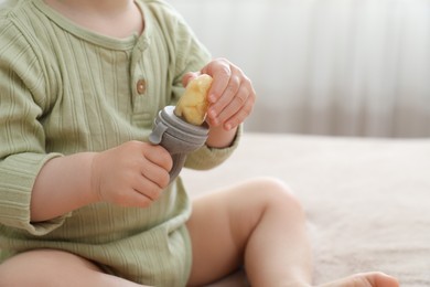 Photo of Baby with nibbler at home, closeup view. Space for text