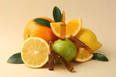 Skincare ampoules with vitamin C, different citrus fruits and leaves on beige background