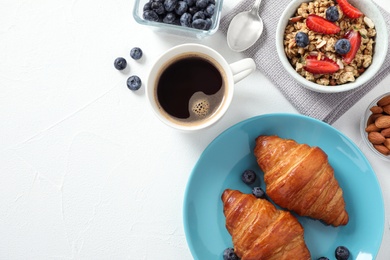 Delicious breakfast served on white table, flat lay. Space for text