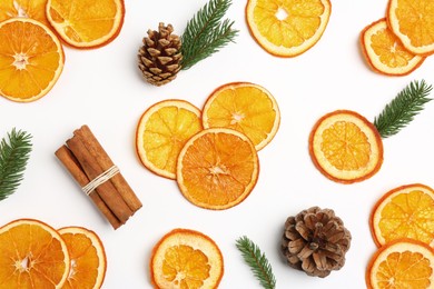 Photo of Flat lay composition with dry orange slices, fir branches, cones and cinnamon sticks on white background