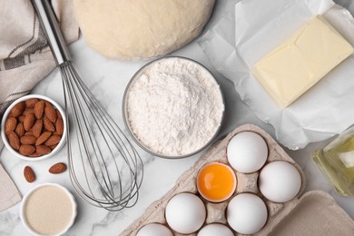 Flat lay composition with dough and flour on white marble table