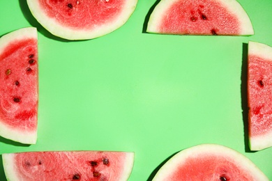Photo of Frame of watermelon slices on green background, flat lay. Space for text